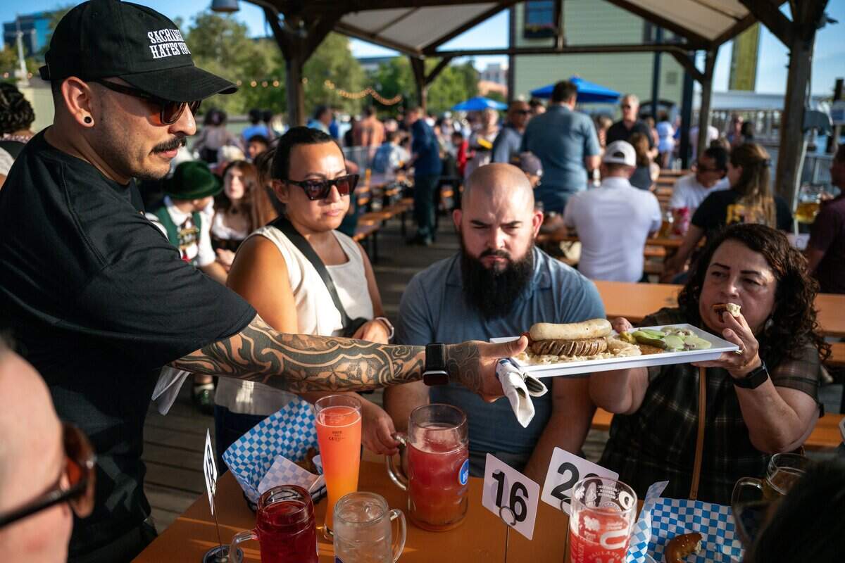 Security manager Ivan Orona, left, serves food at the opening of Der Biergarten Waterfront in Old Sacramento on Friday.