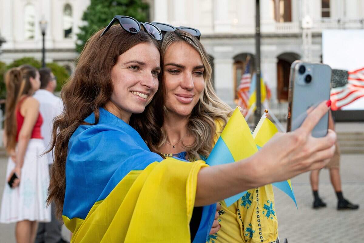 Alina Chernova, left, and her friend Oleksandra Beard pose for a selfie during the 35th anniversary celebration of Ukrainian Independence Day in front of the California Capitol on Monday. The Sacramento region has one of the largest Ukrainian communities in the country.