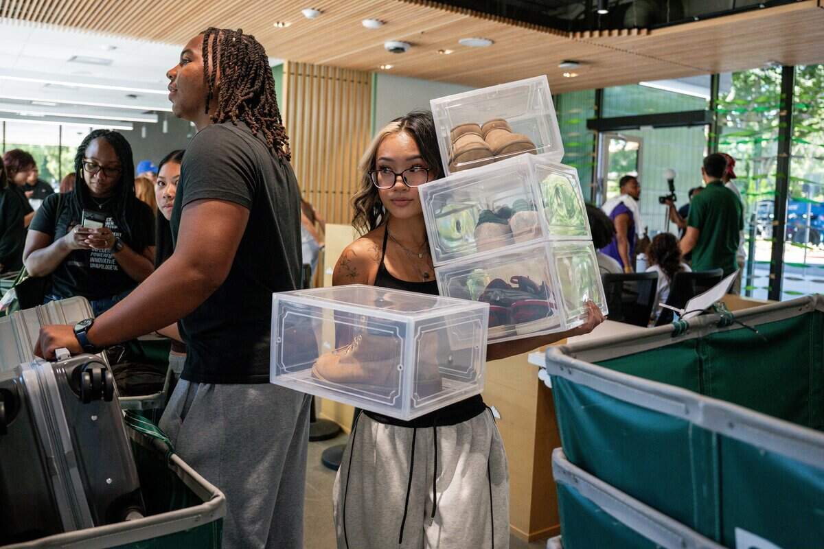 Student Van Nhi Dang moves her shoes into the newly opened Mt. Whitney Hall during Sacramento State's move-in day on Wednesday.