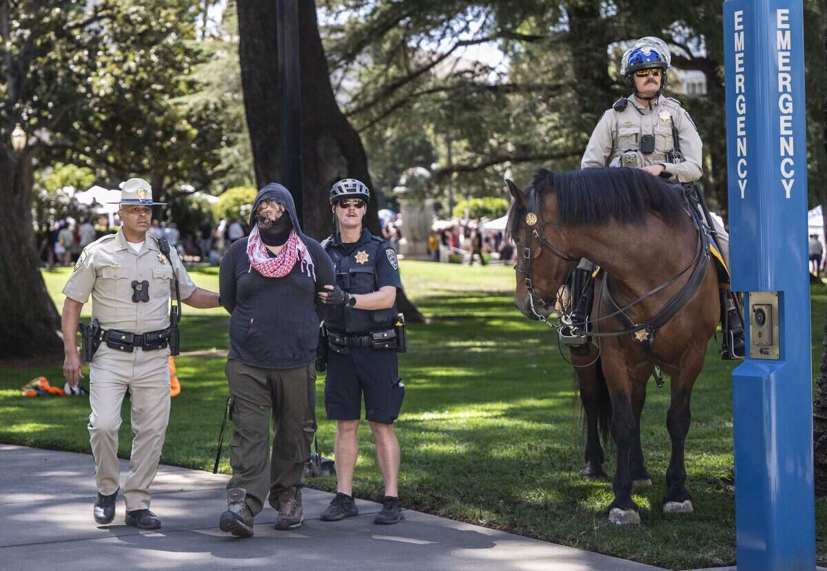 A protester is detained by California Highway Patrol officers after he was involved in an altercation over a flag during online political influencer Nick Shirley's appearance at a Republican news conference at the state Capitol on Wednesday, Aug. 26, 2026.