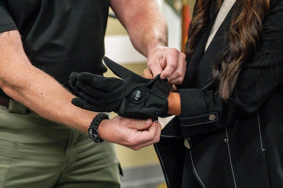A reporter tries on an electric shock glove during a news conference at the Sacramento County Sheriff's Office Headquarters on Thursday.