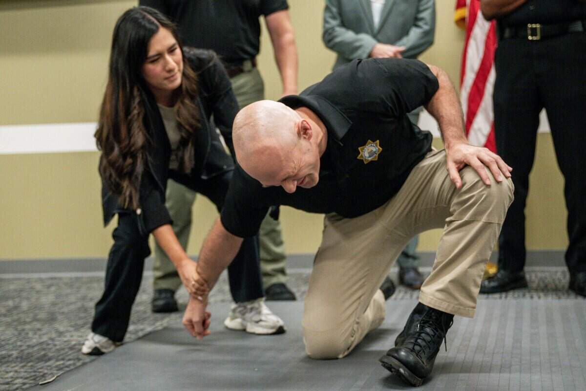 Lt. Will Vernon, right, participates in an electric glove demo session during a news conference at the Sacramento County Sheriff's Office Headquarters on Thursday.