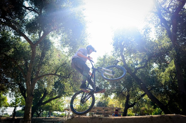 Matt Stuck, of the Santa Cruz Mountains Trail Stewardship, who rebuilt part of the track, goes off a jump on his bike at the BMX course at Calabazas Park in San Jose, Calif., on Wednesday, Aug. 12, 2026. (Shae Hammond/Bay Area News Group)