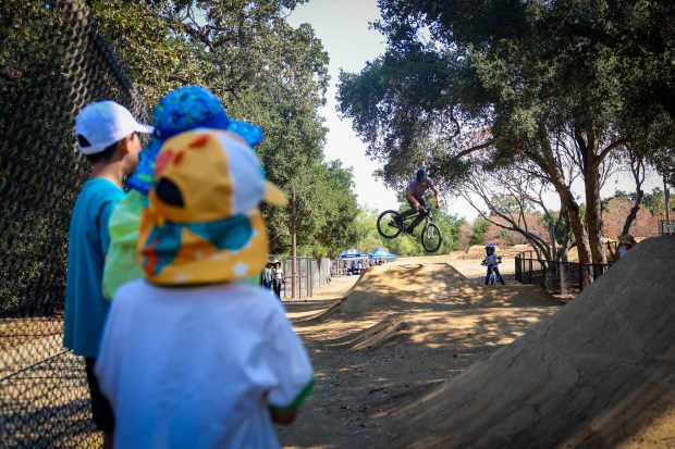 Children watch Matt Stuck, of the Santa Cruz Mountains Trail Stewardship, go off a jump on his bike at the BMX course at Calabazas Park in San Jose, Calif., on Wednesday, Aug. 12, 2026. (Shae Hammond/Bay Area News Group)