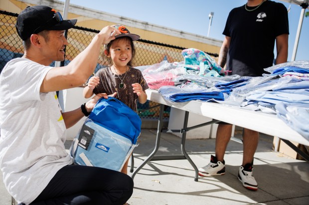 Emily Hoang, 4, reacts after receiving a free backpack with her father, David Hoang, during a National Night Out event in San Jose, Calif., on Aug. 4, 2026. The community event hosted by nonprofits ConXión to Community and Martha's Kitchen featured a free backpack giveaway, a petting zoo, face painting, free food, live music and others. (Dai Sugano/Bay Area News Group)