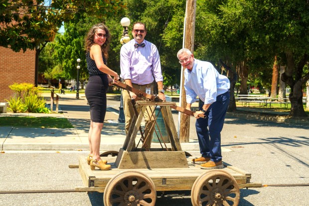 History San Jose CEO Bill Schroh, center, takes a ride on a handcar pushed by Local Color founder and CEO Erin Salazar, left, and Brian Adams, vice president for advancement at Bellarmine College Prep, at History Park in San Jose. Salazar and Adams are being honored at the Valley of Heart's Delight dinner on Oct. 8, 2026. (Tasi Alabastro/History San Jose)