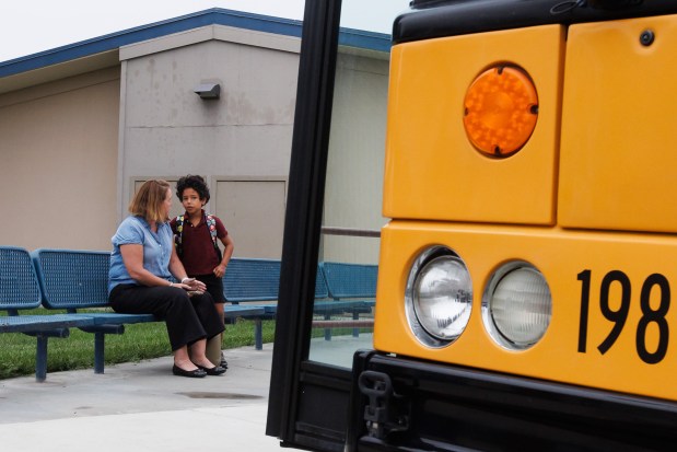 Gio Naughton, 7, and his mother, Maeve Naughton, talk outside Gio's old school, Terrell Elementary School, before getting on a school bus to take him to his new school on Friday, Aug. 7, 2026. Terrell Elementary closed along with four other campuses earlier this year. Gio now attends Rachel Carson Elementary. (Dai Sugano/Bay Area News Group)