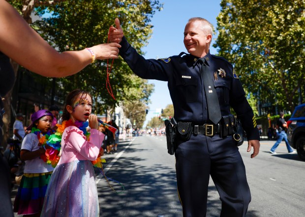 San Jose Police Department Capt. Ngui Scherry hands out beads as he walks south on Market Street during the Silicon Valley PRIDE Parade in downtown San Jose, Calif., on Sunday, Aug. 30, 2026. (Nhat V. Meyer/Bay Area News Group)