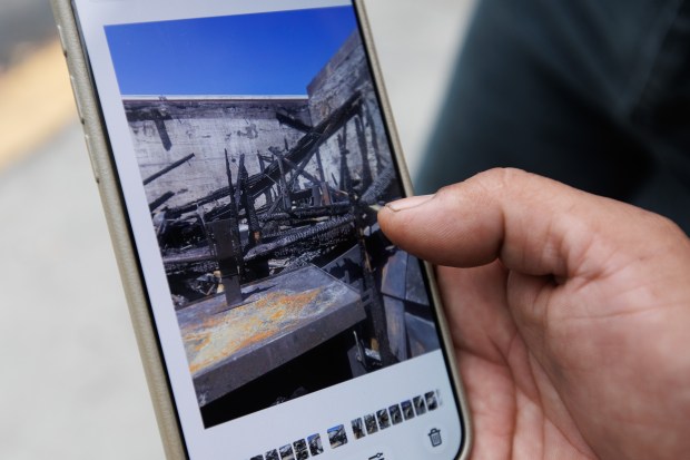 On Aug. 28, 2026, Baja Tires owner Giovanni Pena, 40, shows a photo of his shop, which was damaged by the three-alarm blaze on Tuesday morning. (Dai Sugano/Bay Area News Group)