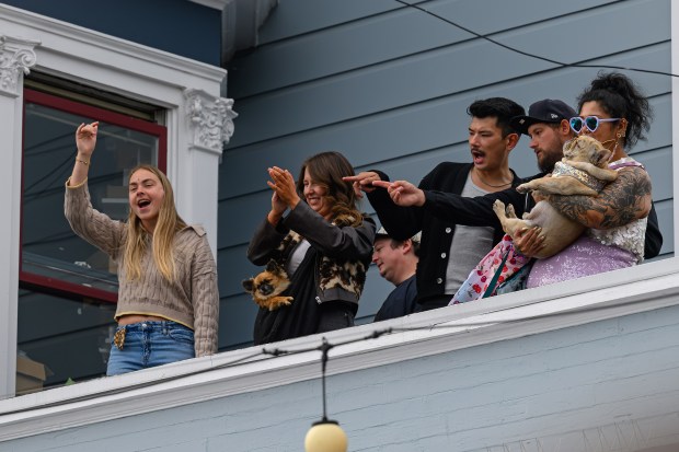 Music fans standing on the roof of a building react to the music of Train, who performed on stage in front of the Mad Dog in the Fog in San Francisco on Thursday, Aug. 27, 2026. (Jose Carlos Fajardo/Bay Area News Group)