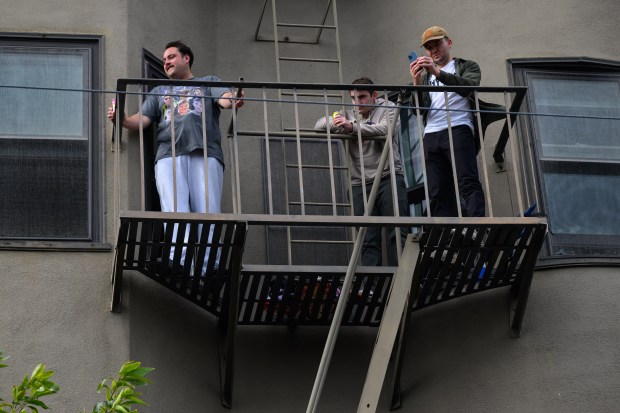 Music fans stand on a second-story fire escape to listen to Train as the band performs in front of the Mad Dog in the Fog in San Francisco on Thursday, Aug. 27, 2026. (Jose Carlos Fajardo/Bay Area News Group)