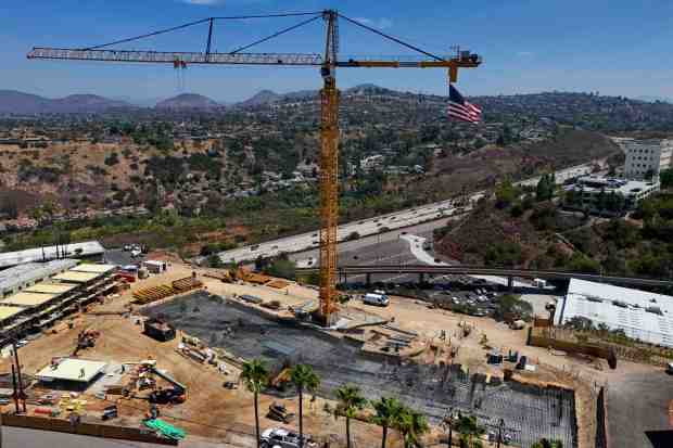 Workers labor in the summer heat at San Diego State University on a big expansion of student housing. (Meg McLaughlin / The San Diego Union-Tribune)