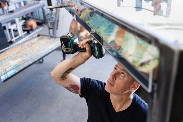 Chula Vista, CA - Michael Leaf tightens the screws on a table Wednesday, Aug. 19, 2026, at his metal workshop in Chula Vista, CA. Leaf is using pieces of the old US and Mexico border wall to create his artwork. (Luke Johnson / The San Diego Union-Tribune)