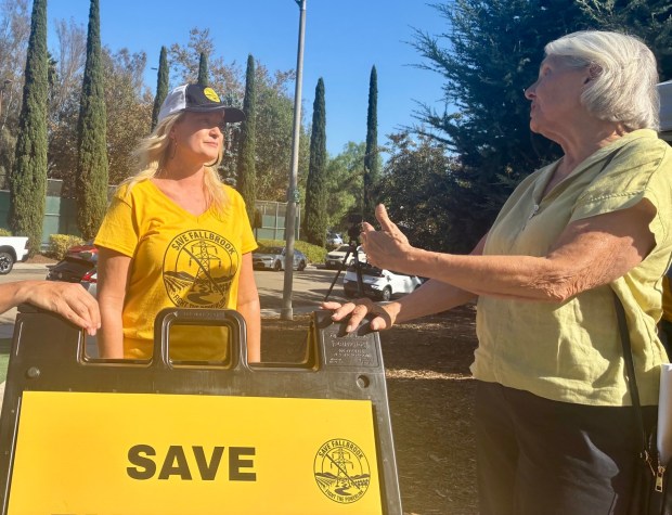 Stephani Baxter, left, of the Save Fallbrook group that is opposed to the Golden Pacific Powerlink, listens to Fallbrook resident Kathy Wehe outside the Fallbrook Community Center on Aug. 25, 2026. (Rob Nikolewski/The San Diego Union-Tribune)