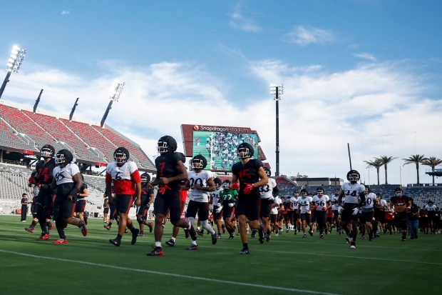 San Diego State players run onto the field during scrimmage at Snapdragon Stadium on Saturday, Aug. 15, 2026 in San Diego, California. (Meg McLaughlin / The San Diego Union-Tribune)