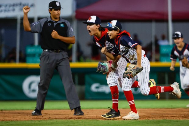 Sweetwater Valley's Tempe Tran #2 and Mateo Ruiz #7 celebrate after turning a double play against Hawaii' during the Little League West Regional final at Al Houghton Stadium on Friday, Aug. 14, 2026 in San Bernardino, California. (Meg McLaughlin / The San Diego Union-Tribune)