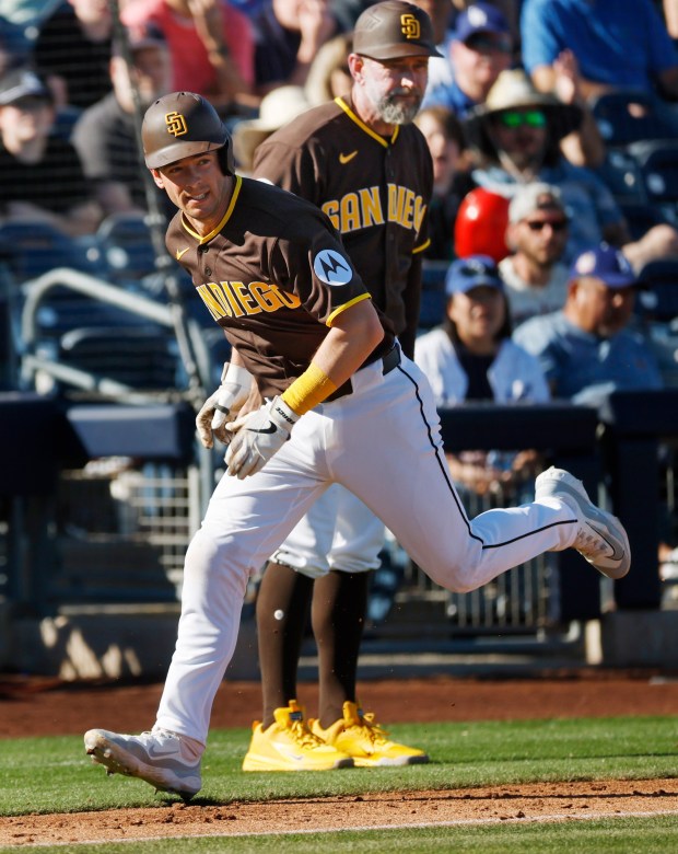 Nick Solak of the San Diego Padres runs by third-base coach Bob Henley to score against the Los Angeles Dodgers during a spring training game on February 22, 2026 in Peoria, AZ. (K.C. Alfred / The San Diego Union-Tribune)