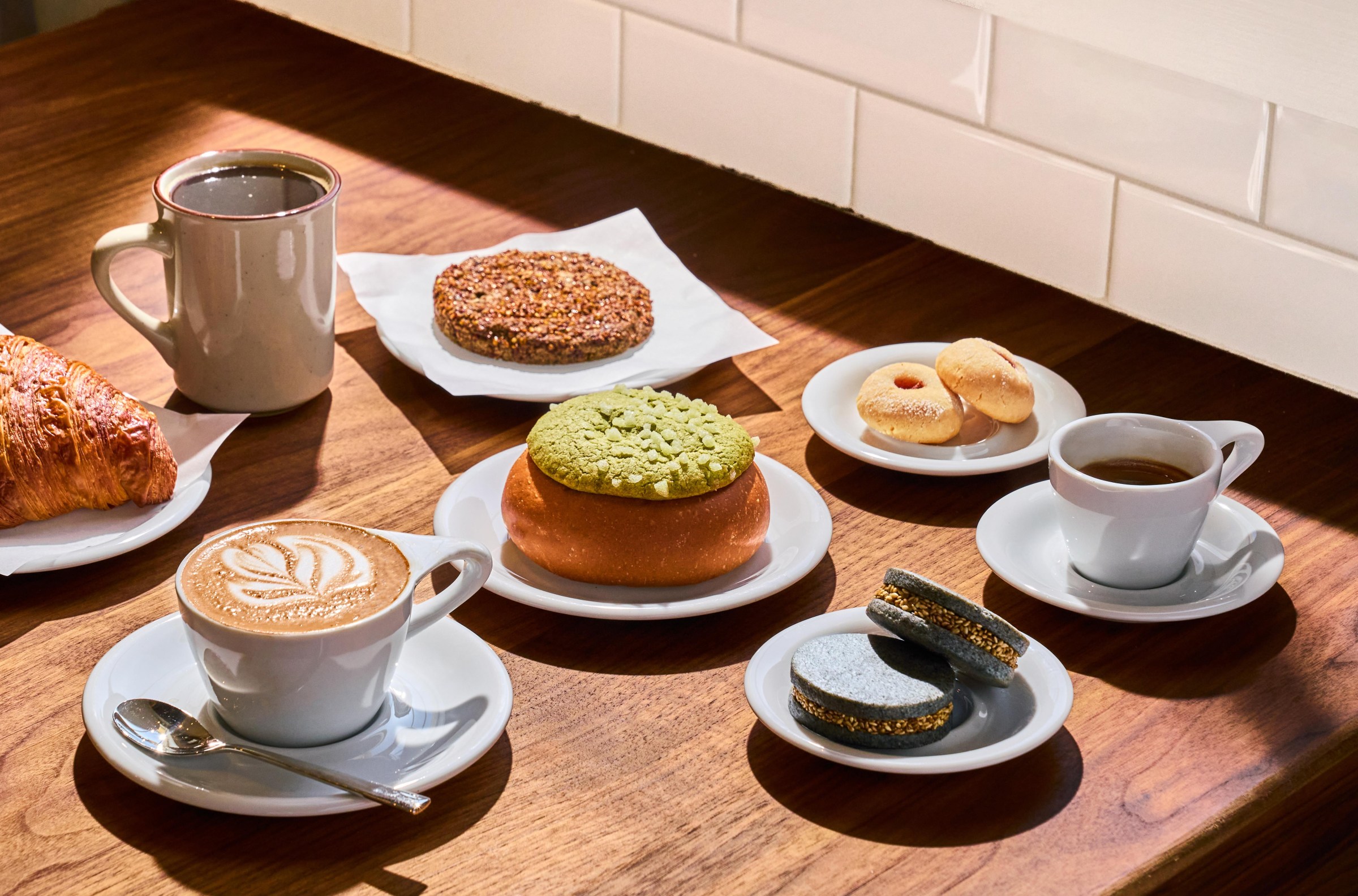 A selection of pastries from Breadbelly, next to a latte and espresso at the Mess Hall in San Francisco.