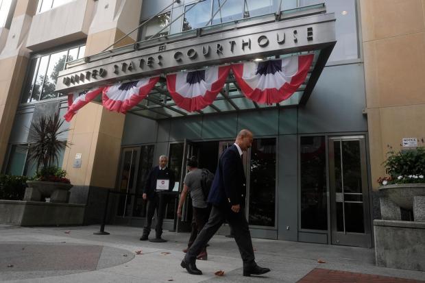 People walk outside of a federal courthouse in Oakland, California.