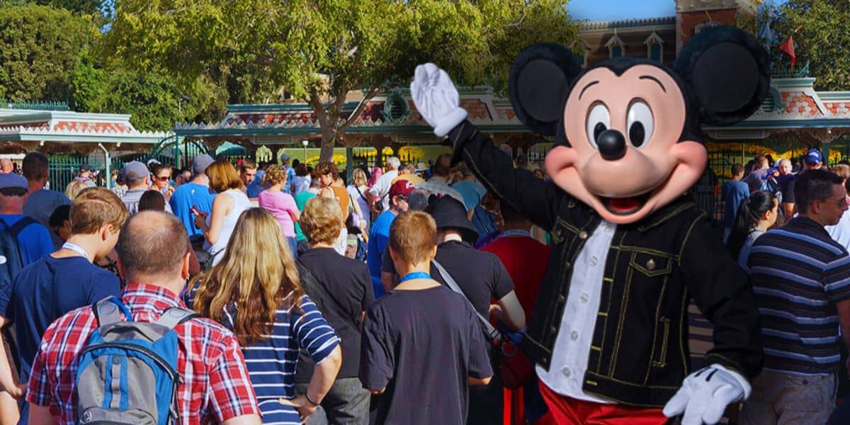 Mickey Mouse waving his hand at the Disneyland Park in California entrance as guests form multiple lines to get inside the Disney theme park. Disney park fined by government.
