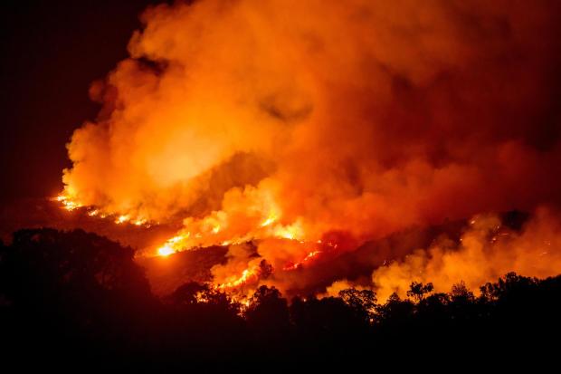 The Gann Fire burns along a hillside near Copperopolis on Tuesday, Aug. 4, 2026, in Calaveras County, Calif. (AP Photo/Noah Berger)