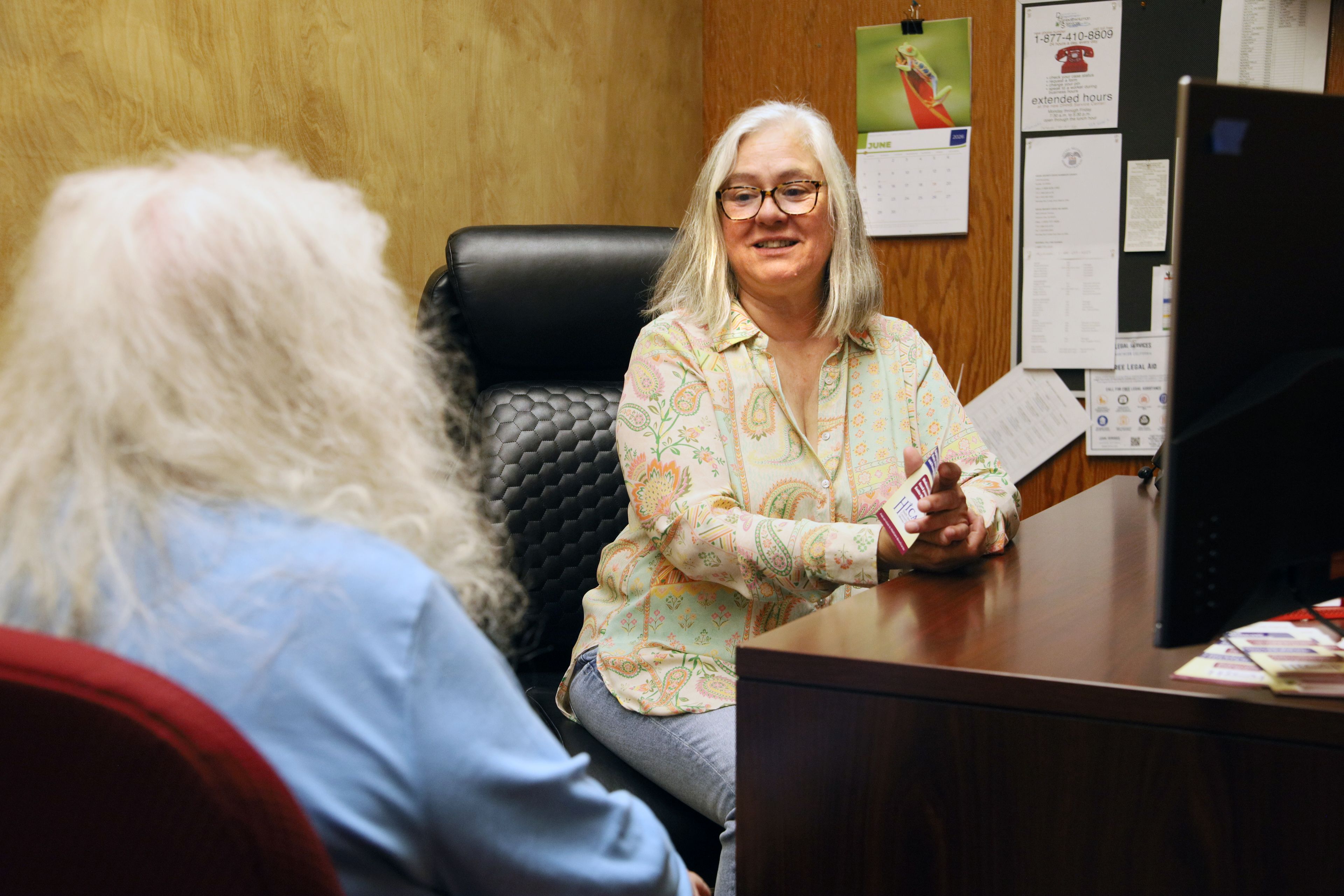 Rosana Bruhnke sitting at her desk, speaking to a client.