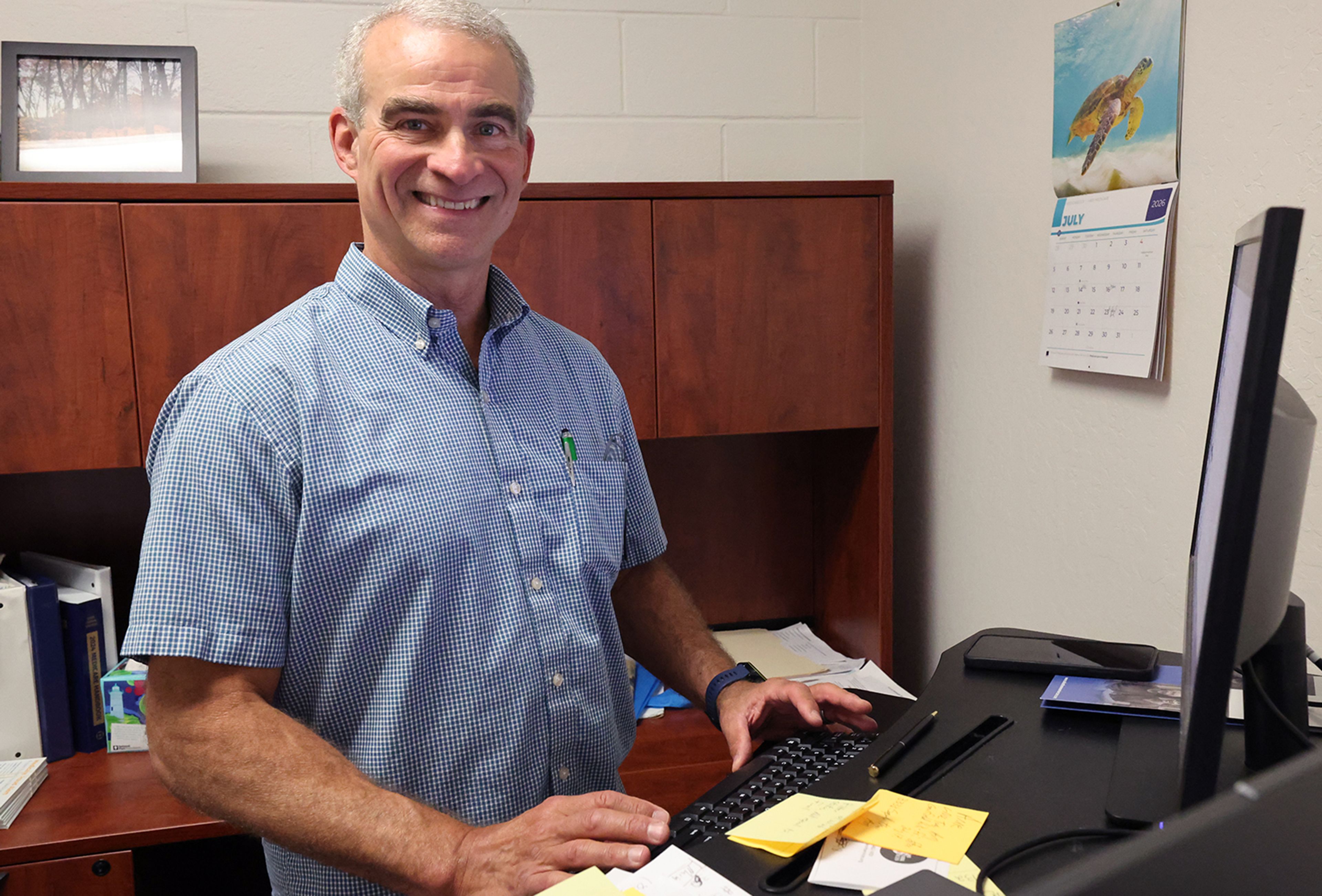 Bill Proulx, smiling, in front of his computer.