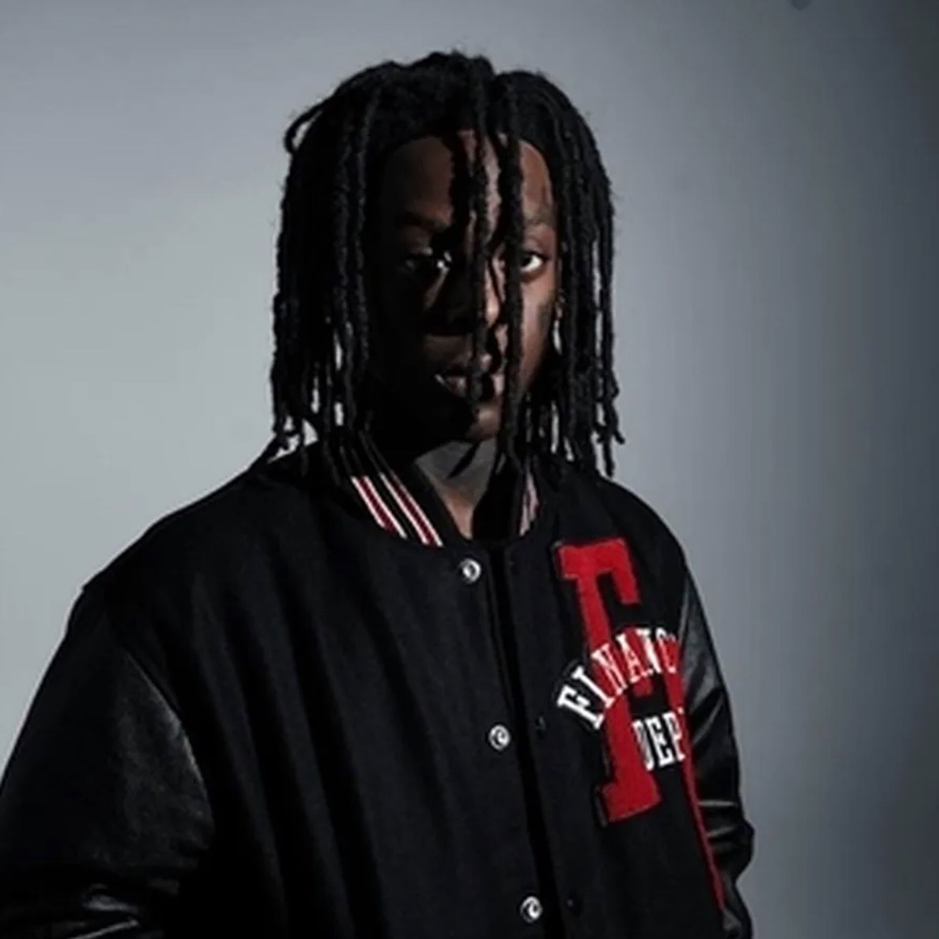 Raq Baby staring at the camera through his dreadlocks.