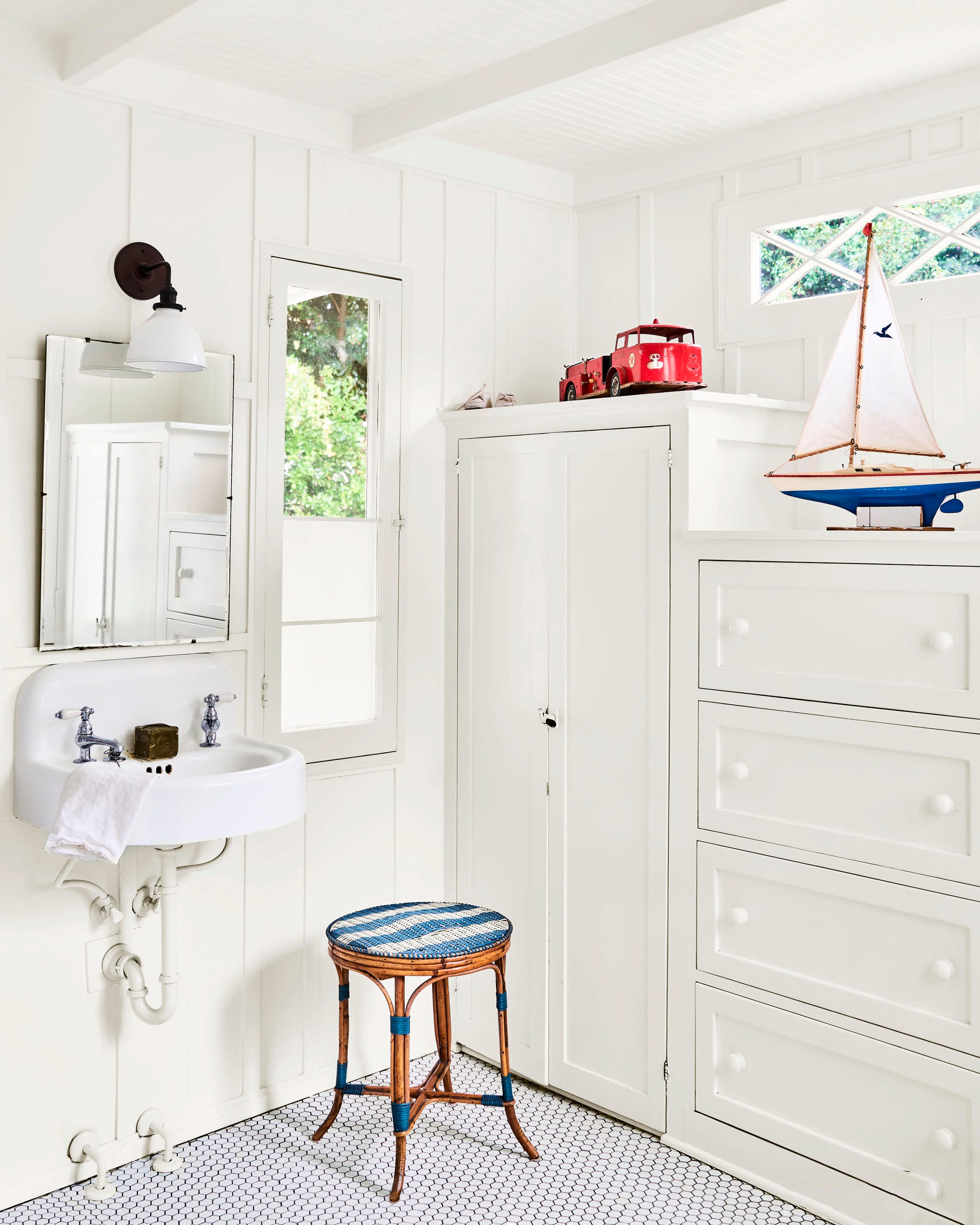bathroom with built in cabinets and drawers painted white next to a small sink bathroom with built in cabinets and drawers painted white next to a small sink
