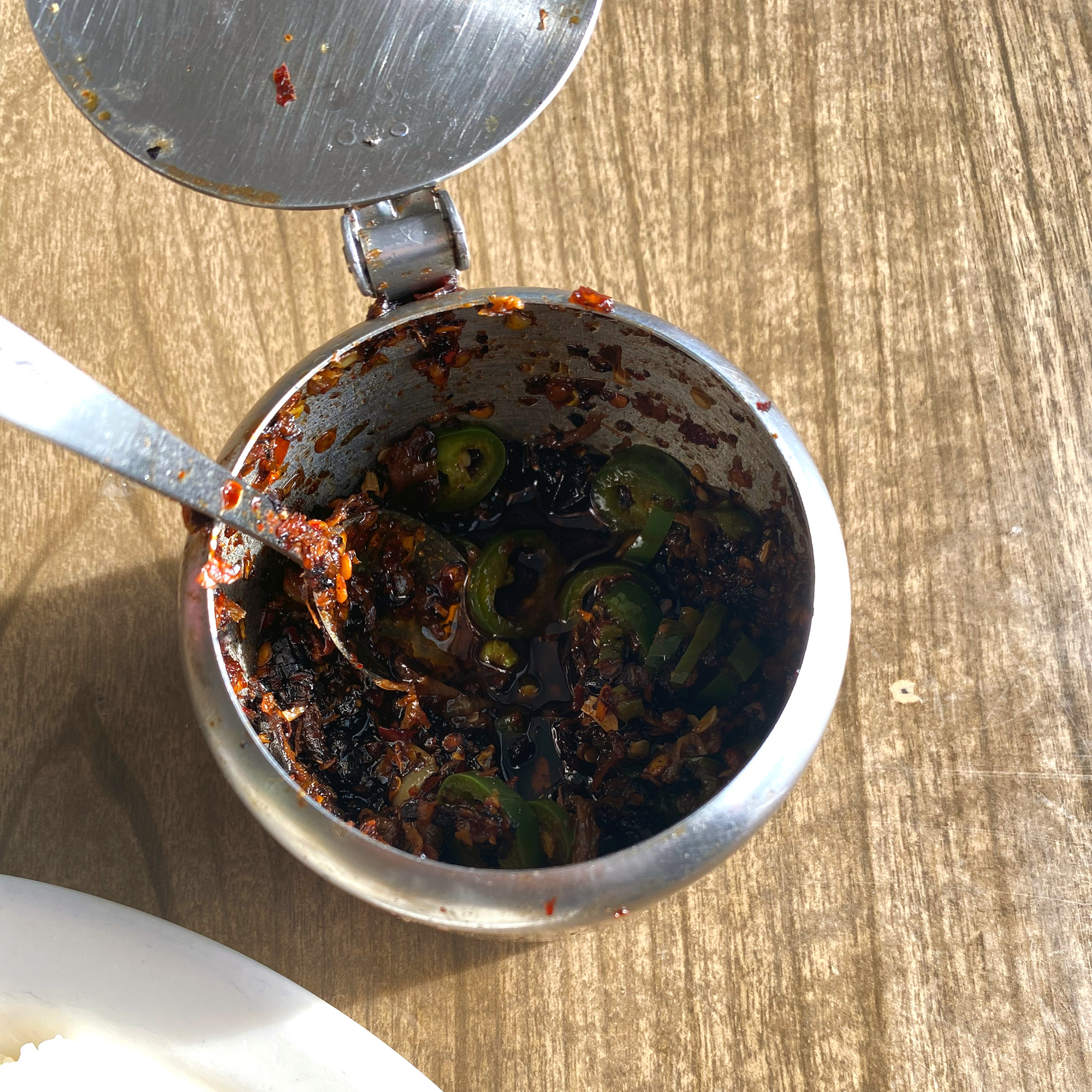 Metal container with chili sauce.