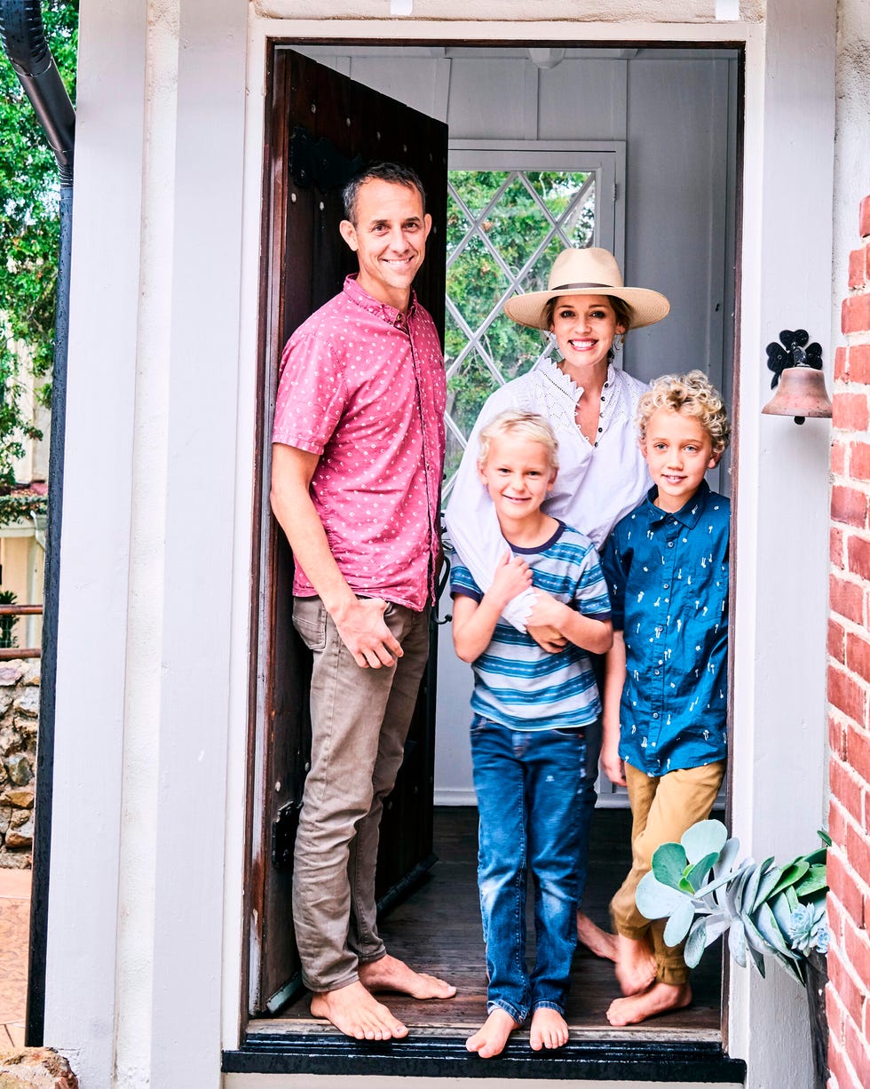 woman, man, and two boys standing in door frame of home