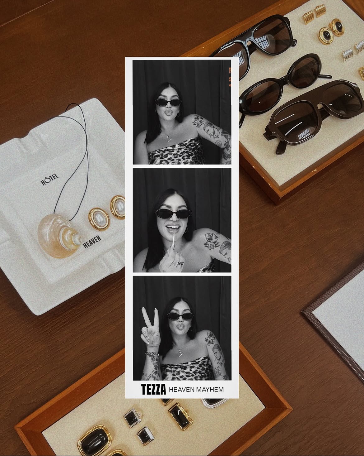 Strip of three black-and-white photos of a woman with sunglasses, tattoos, and a patterned top, making different gestures.