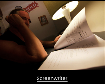 Person reading a script at a desk with a lamp, a framed picture, and a 'Sold' sign in the background.