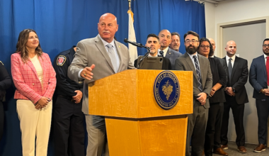 man at podium with people behind him