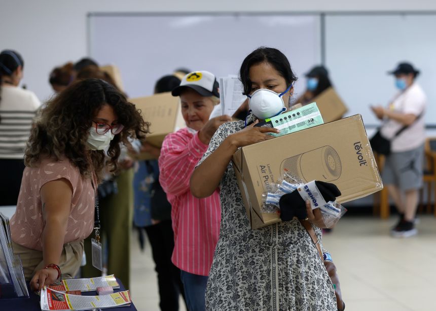 Residents receive free air purifiers and supplies during a health services pop-up in Los Angeles.