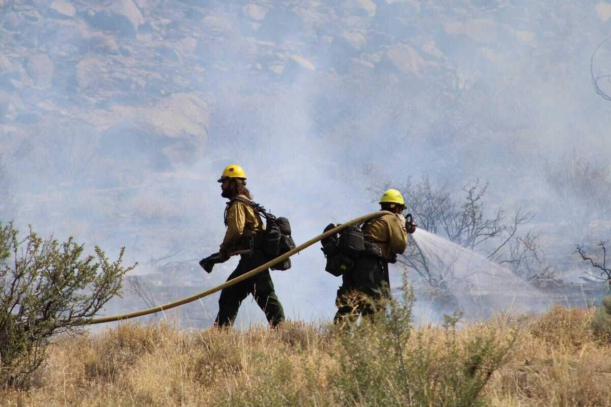 Two firefighters work the fire line on the Bug Fire on Wednesday, Aug. 12, 2026. The wildfire has burned across Lassen and Sierra counties and into northern Nevada.