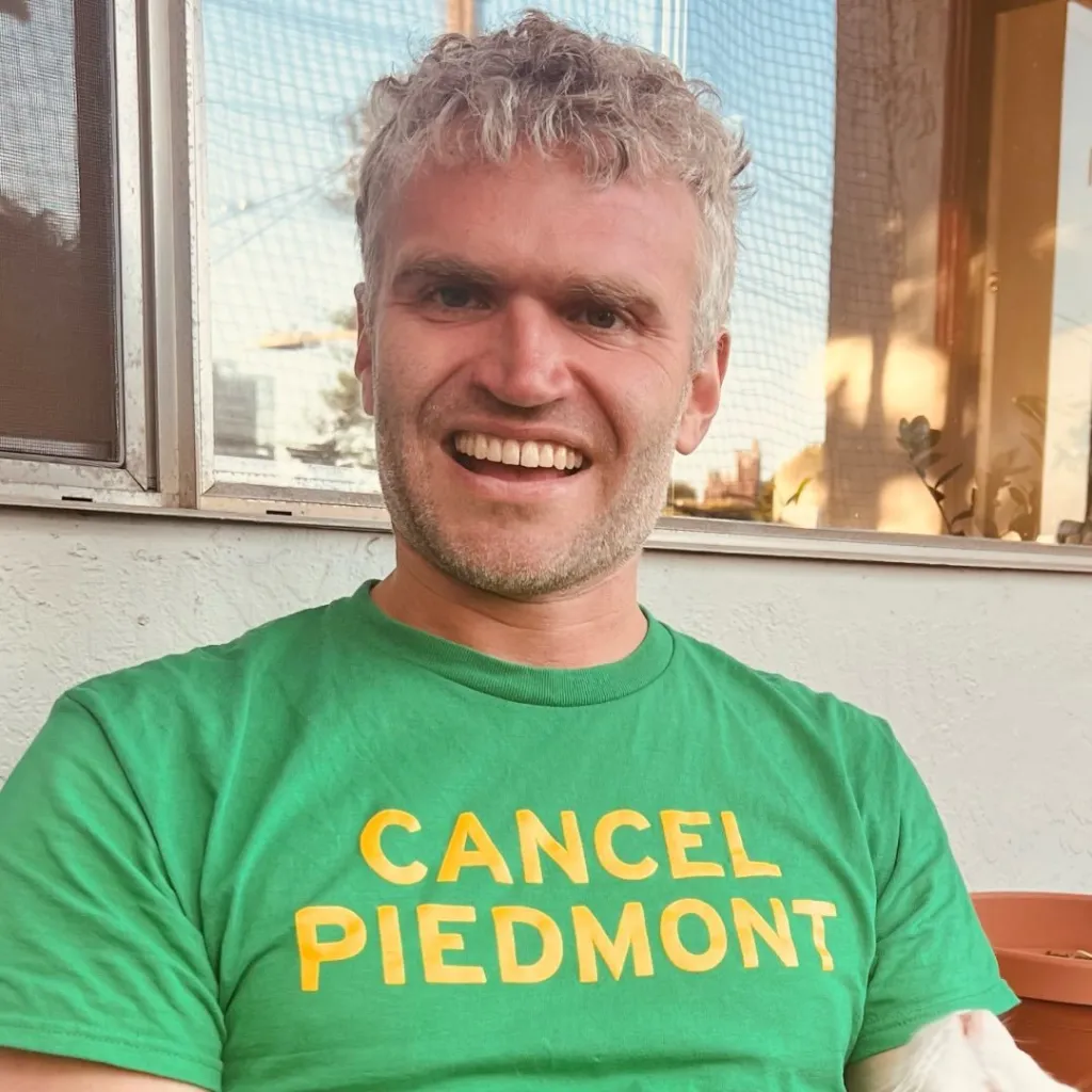Jesse Rosemoore in a green "CANCEL PIEDMONT" t-shirt.