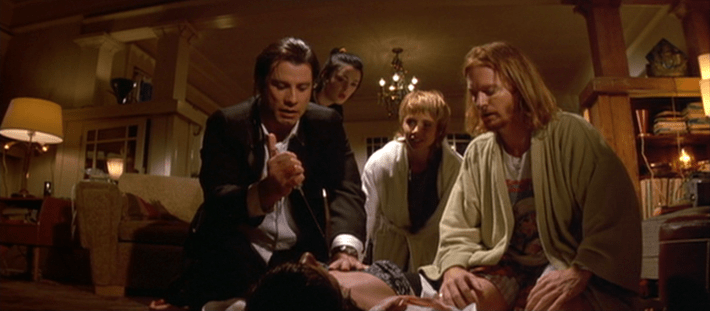 Vincent (John Travolta) prepares to inject Mia (Uma Thurman) with an adrenaline shot as Lance (Eric Stoltz), Jody (Rosanna Arquette), and Trudi (Bronagh Gallagher) look on