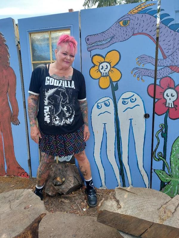 woman standing in front of a mural
