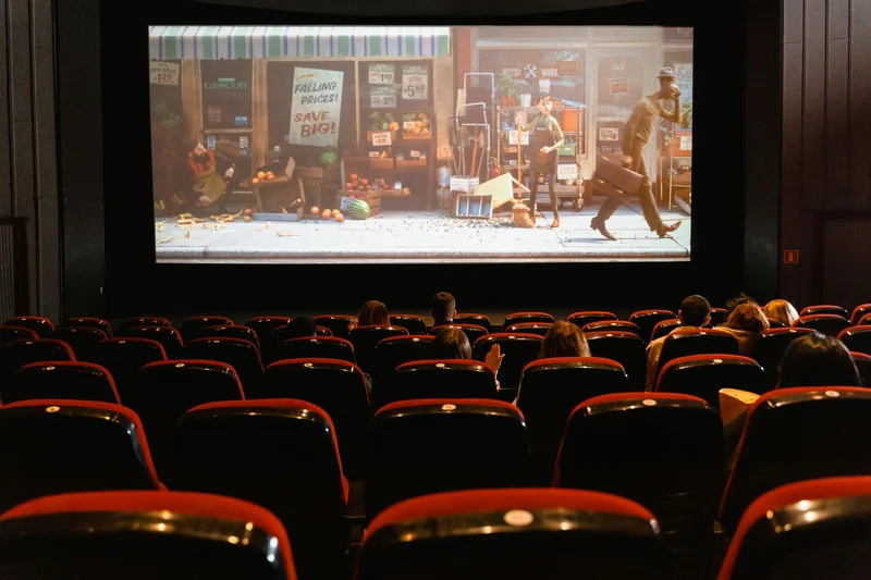 A cozy indoor movie theater showing an animated film to a small audience. (stock photo via Pexels)