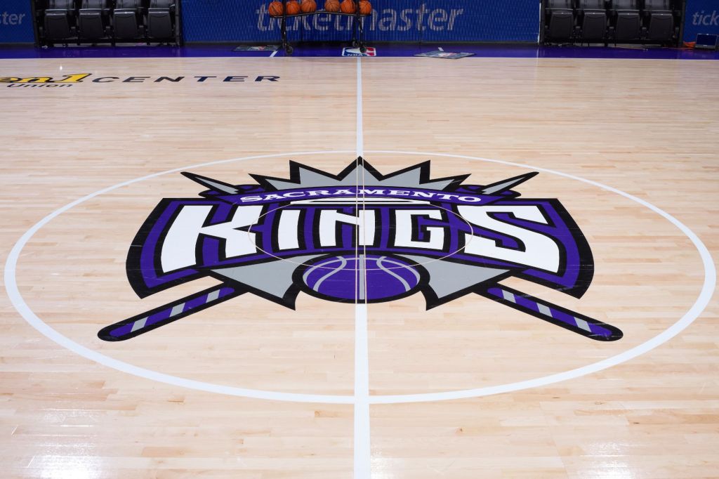 An image collage containing 1 images, Image 1 shows The Sacramento Kings logo at center court on a basketball court