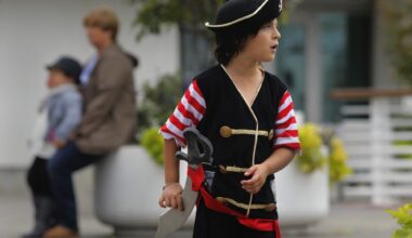 A young boy dressed as a pirate glances around curiously.