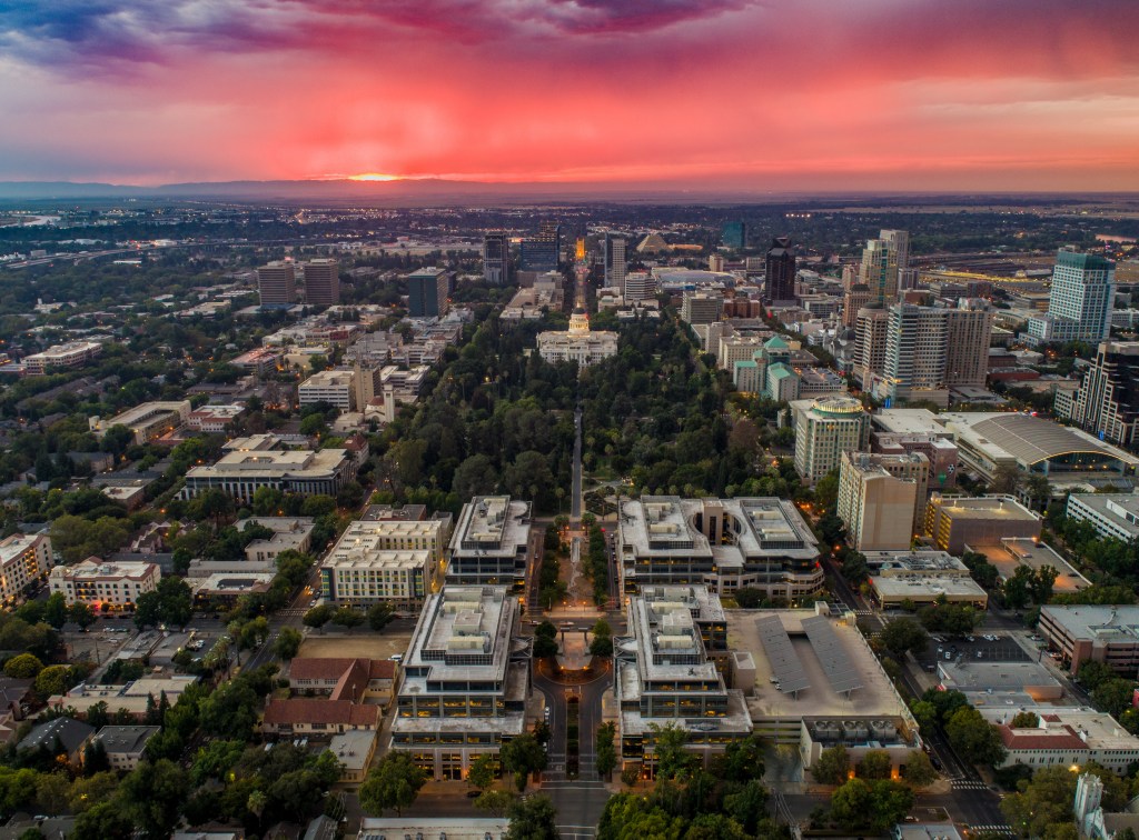 Aerial view of downtown Sacramento with a red and orange sunset.