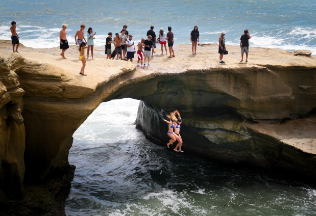 Despite warnings from San Diego City Lifeguards over the PA system, several individuals chose to continue diving off the cliffs at Sunset Cliffs in San Diego, CA, after the lifeguards left the area late Wednesday afternoon.  (Nelvin C. Cepeda / The San Diego Union-Tribune)
