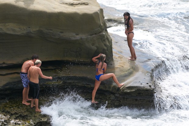 Despite warnings from San Diego City Lifeguards over the PA system, several individuals chose to continue diving off the cliffs at Sunset Cliffs in San Diego, CA, after the lifeguards left the area late Wednesday afternoon.  (Nelvin C. Cepeda / The San Diego Union-Tribune)