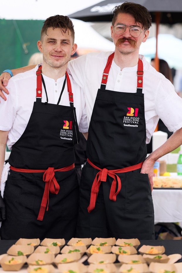 Chefs and co-owners Jacob Jordan, left, and Nic Webber of Michelin Guide-recommended 24 Suns restaurant in Oceanside, prep food samples at the 2025 San Diego Wine + Food Festival's Grand Tasting Event. (SDFW)