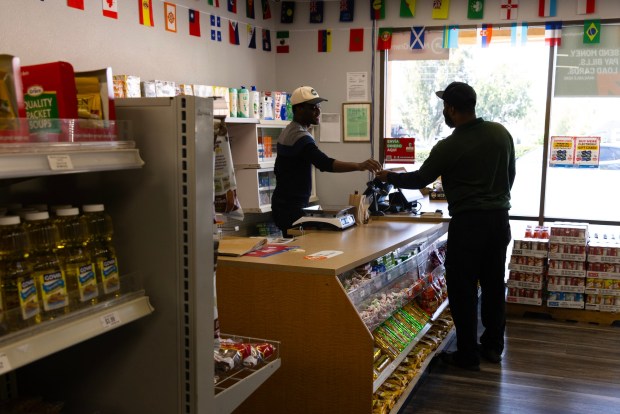 El Cajon, CA - Emanuel Lexius helps a customer at Miche Caribbean Market on Friday, July 31, 2026, in El Cajon, CA. (Luke Johnson / The San Diego Union-Tribune)