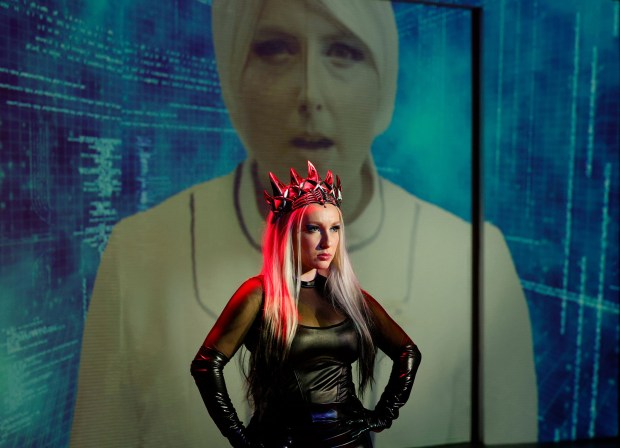 Samy Berman, foreground, as Killer Queen and Audrey Ward, on video screen in background, as Khashoggi in New Village Arts' "We Will Rock You." (JEDZANT Photography)