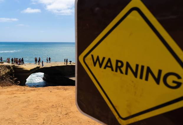 San Diego, CA - People jump into the ocean despite warnings from San Diego Lifeguards at Sunset Cliffs on Wednesday, July 29, 2026, in San Diego, CA. (Brandon Pollard / The San Diego Union-Tribune)