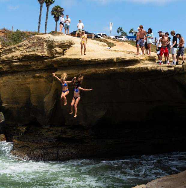 San Diego, CA - People jump into the ocean despite warnings from San Diego Lifeguards at Sunset Cliffs on Wednesday, July 29, 2026, in San Diego, CA. (Brandon Pollard / The San Diego Union-Tribune)